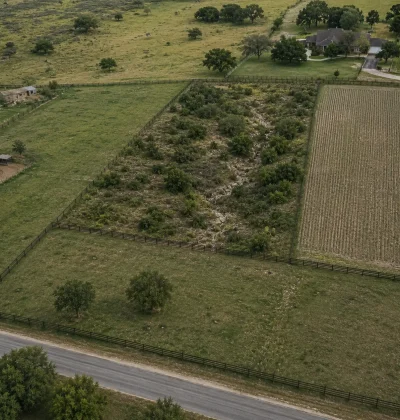 Aerial view of a difficult landlocked parcel surrounded by neighboring properties and fencing, illustrating the challenges of selling problem land without direct road access.
